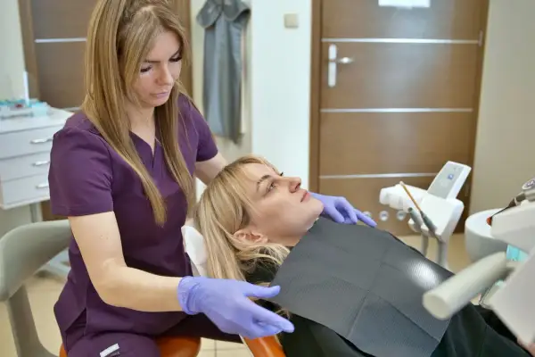 Dentystka bada pacjentkę, sprawdzając, jak ząb reaguje na ciepło.